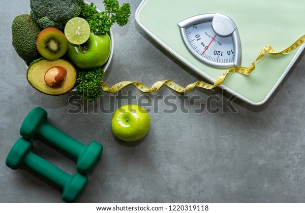 Diet and Healthy life loss weight slim Concept. Organic\
Green apple and Weight scale measure tap with nutrition vegan\
vegetable and sport equipment gym for body women diet fit.  Top\
view copy space.  