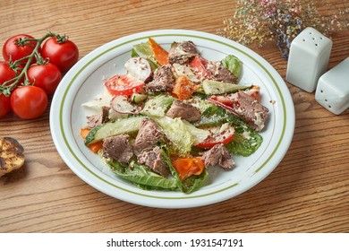 Diet And Healthy Salad With Veal, Vegetables And Tomatoes, Parmesan, Served In A White Plate On A Wooden Background. Restaurant Food