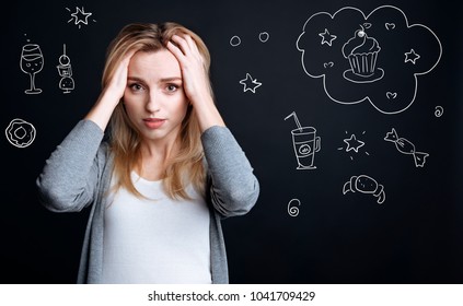 Diet. Hungry Young Woman Touching Her Head And Feeling Worried While Being On A Diet And Dreaming About Tasty Unhealthy Food