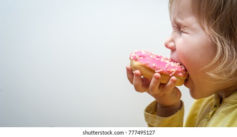 Diet For Kids. Happy Child Eating Donuts. Tasty Food For Kids. Kid Is Looking On Doughnut. Junk Food Addiction. 