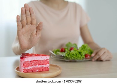 Diet And Lose Weight Concept. Woman Reject To Eat Strawberry Cake And Choose Eat Salad For Good Health And Slim Shape. 