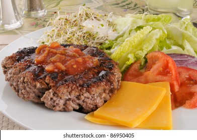 A Diet Lunch With A Ground Beef Patty, Salad And Tomatoes