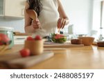 Diet to maintain figure. Fresh food is important for weight loss and perfect health. woman cutting vegetables Tomatoes into a bowl to make a salad to eat at home. Health care concept.