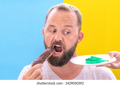 Diet and the problem of choice. Funny beard man doubts to eat an eclair seeing measuring tape