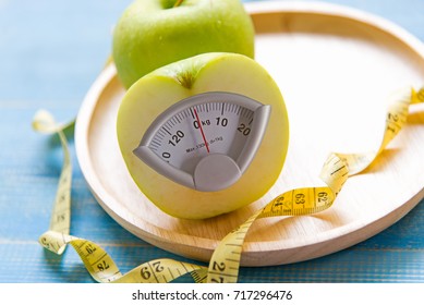 Diet slimming loss. Green apple fruit with weight scale and measuring tape for obesity body healthy. Diet and Healthy Concept.