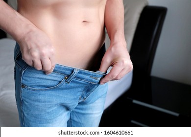 Diet And Slimming, Man In Jeans With Naked Belly Showing Weight Loss. Concept Of Erection, Impotence, Penis Size