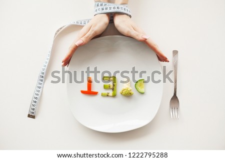 Diet or weight control concept. Centimeter tape and fork on a white background with a place for inserting text. concept of health, weight loss, diet, proper nutrition.