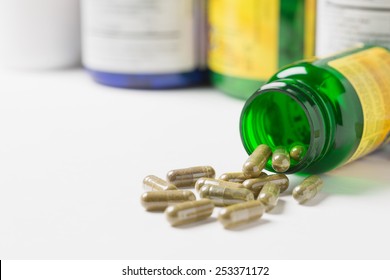 Dietary Supplement Capsules Spilled From A Bottle Onto A Table. Shallow Depth Of Field.