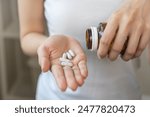 Dietary supplement or sick, asian young woman, girl hold pills, drugs medical tablet on hand pouring capsules from medication bottle, take vitamin for treatment for skin, hair at home, healthcare.