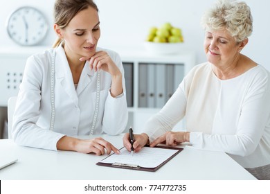 Dietician And Diabetic Patient With Measure Tape Discussing Daily Healthy Diet At The Hospital