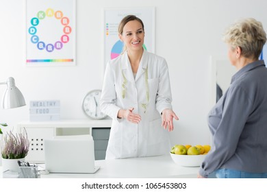 Dietician With Measuring Tape Welcoming Her Elderly Client At An Appointment To Plan Weight Loss