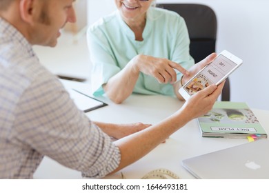 Dietician Showing Her Patient Phone Application Planning The Diet