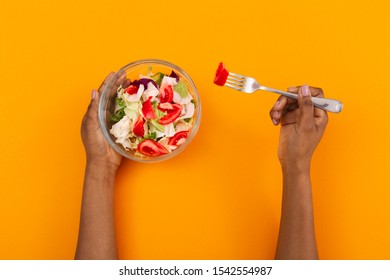 Dieting Concept. Top View Of Afro Female Eating Fresh Salad, Orange Background With Copy Space