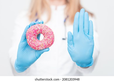 Dieting And Good Health Concept. Junk Food In The Hands Of A Doctor.