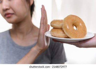 Dieting Or Good Health Concept. Young Woman Rejecting Junk Food Or Unhealthy Food Such Donut Because Concern About Health Sickness And Body Weight. Young Woman Self Care Food Control Diet Concept.