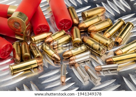 Difference of size of ammunition gun bullets on daimond plate background  