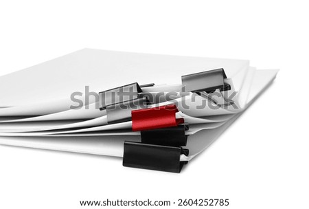 Difference, uniqueness, individuality. Pile of documents with black binder clips and one red on white background