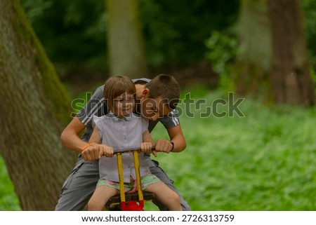 Differences between supervising with screens and outdoor activities observed, Modern parenting contrasting outdoor play and screen supervision beneath large tree