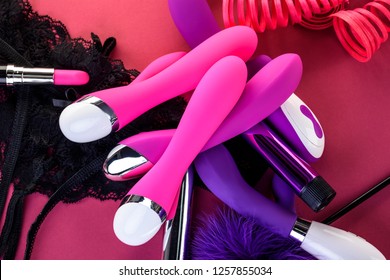 different adult sex toys on a pink background with black underwear