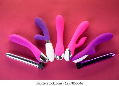 Different Adult Sex Toys On A Pink Background With Black Underwear