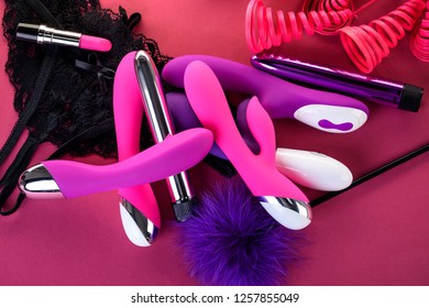 different adult sex toys on a pink background with black underwear
