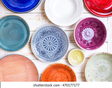 Different antique vintage multicolored empty plates and bowls on a white old wooden table. Table setting. Shabby chic/retro style. Top view. Tableware. Rustic kitchen. Set of plates - Powered by Shutterstock