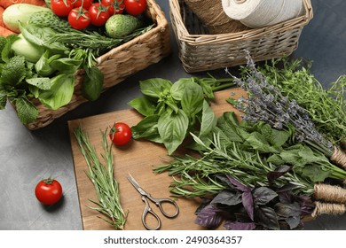 Different aromatic herbs, vegetables, scissors and threads on gray table, closeup - Powered by Shutterstock