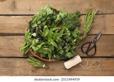 Different aromatic herbs in wicker basket, thread and scissors on wooden table, flat lay - Powered by Shutterstock