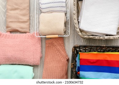 Different baskets and clean clothes on grey background, closeup