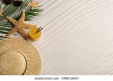 Different Beach Accessories And Glass Of Cocktail On Sand, Flat Lay. Space For Text