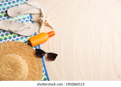 Different beach accessories on sand, flat lay. Space for text - Shutterstock ID 1902860113