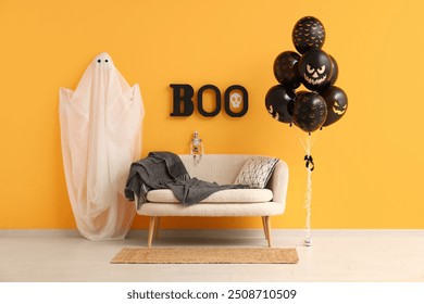 Different black Halloween balloons, sofa, ghost and text BOO hanging on orange wall in room - Powered by Shutterstock