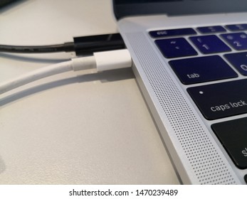 different black and white usb type c cable connect to labtop.