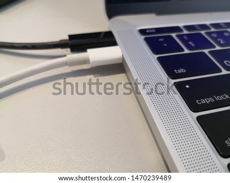 different black and white usb type c cable connect to labtop.