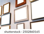 Different blank empty cut out frames paintings photos pictures on a gallery art museum wall, copy space template mockup, art exhibition concept, nobody, angle, generic. Works of art hanging on a wall