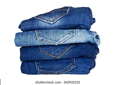 Lot of different blue jeans isolated on white background