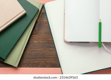 Different books and open notepad on rustic table. Space for text