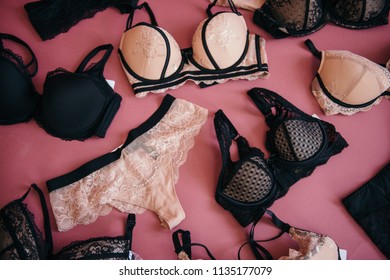 Different Bra And Panties On Pink Background. Black And Beige. Big Choice Of Gorgeous Brasю Colorful Women Sexy Underwear. Top View, Flat Lay. Female Wardrobe, Shopping Concept. Fashion Lace Lingerie.