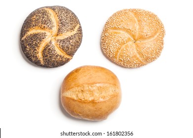 Different bread rolls, natural, covered with sesame and with poppy seeds, typical German breakfast food. Studio shot, cutout, isolated on white background.