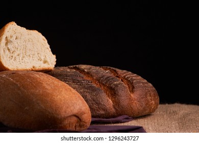 Different bread and wheat on the rustic table. Selective focus, close up - Shutterstock ID 1296243727