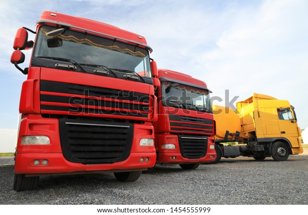 Different\
bright trucks parked outdoors. Modern\
transport