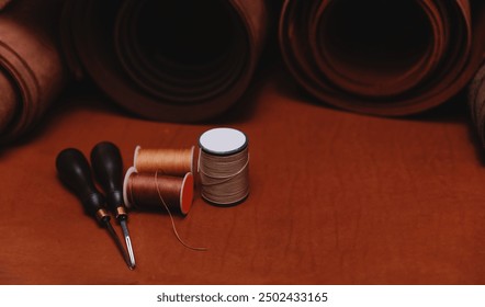 Different brown rolled leather, threads and tool in shoemaker workshop, banner background tailor footwear. - Powered by Shutterstock