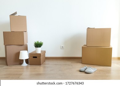 Different cardboard boxes for moving at room interior movement or delivery concept, empty wall  with copy space for your text