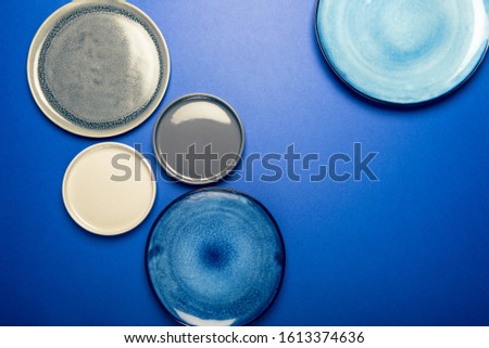 Different Ceramic Empty Blue and Grey Plates on Blue Background, Top View, Copy Space