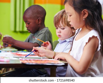 Different Children Concentrate Together Painting Pictures In Kindergarten