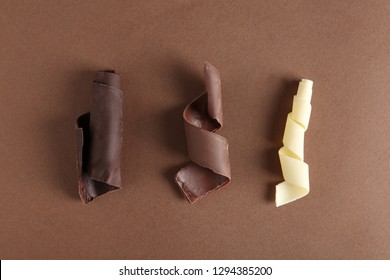 Different Chocolate Curls On Color Background, Top View