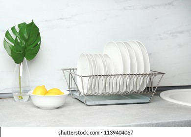 Different clean plates in dish drying rack on kitchen counter