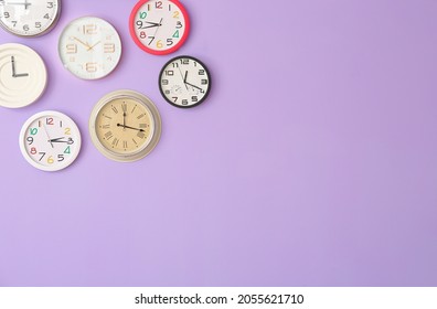 Different Clocks Hanging On Color Wall