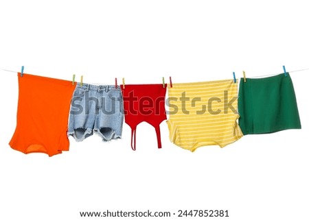Different clothes drying on laundry line against white background