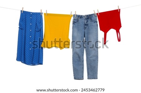 Different clothes drying on laundry line against white background